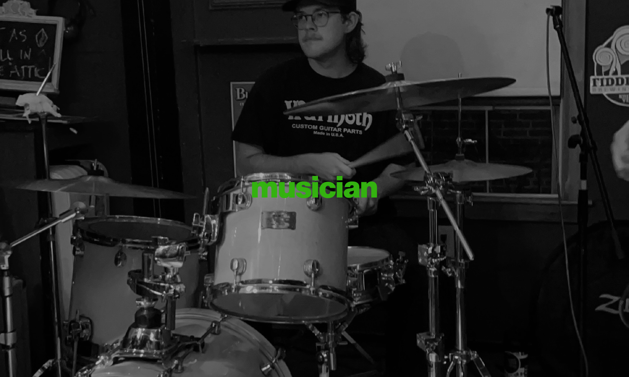 A black and white photo of Henry Pestana playing drums.