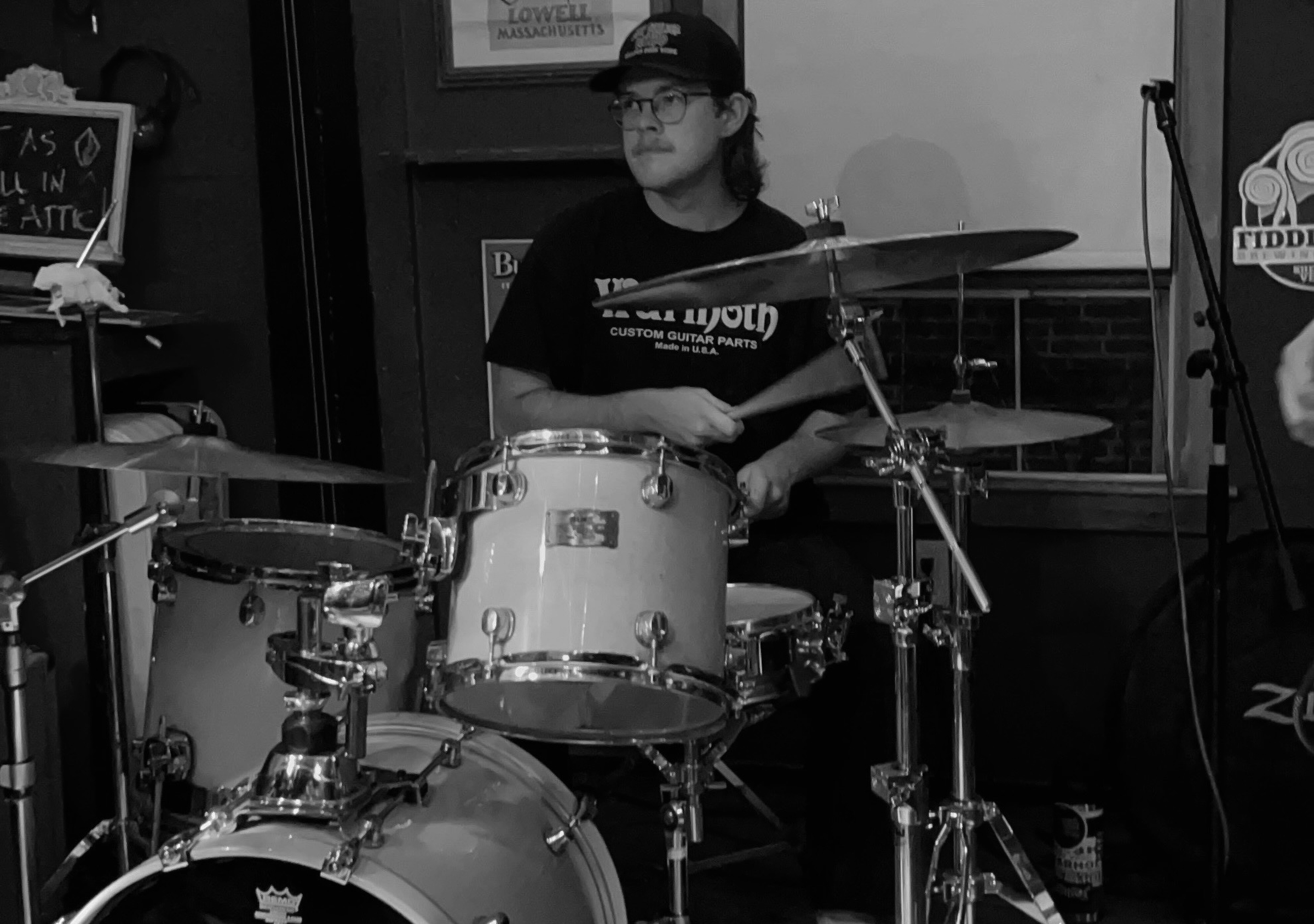 A black and white photo of Henry Pestana playing drums.